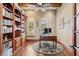 Well-lit home office with built-in bookcase, decorative rug, and transom windows with plantation shutters at 9253 Tibet Pointe Cir, Windermere, FL 34786