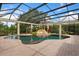 Screened-in pool with rock waterfall feature surrounded by lush landscaping and brick pavers at 9253 Tibet Pointe Cir, Windermere, FL 34786