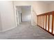 Carpeted hallway with wooden railing leading to additional rooms at 947 Bird Bay Ct # 205, Lake Mary, FL 32746