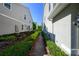 Townhome backyard, features green grass, lush landscaping, and a brick paver pathway at 978 E 10Th St, Apopka, FL 32703