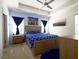 Bright bedroom featuring a tray ceiling, ceiling fan, art and blue accent wall at 978 E 10Th St, Apopka, FL 32703