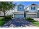 Charming townhome with a two-car garage and brick paved driveway, complemented by lush landscaping at 978 E 10Th St, Apopka, FL 32703