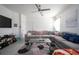 Spacious living room with tile flooring, a large sectional sofa, ceiling fan, and modern decor at 978 E 10Th St, Apopka, FL 32703