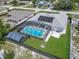 Aerial shot of a single Gathering house with a pool, screened-in lanai, solar panels, and fenced yard at 1129 Madura Dr, Deltona, FL 32725
