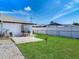 Well-kept backyard featuring a fire pit, green grass, and a white fence at 1129 Madura Dr, Deltona, FL 32725