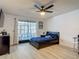 Bright bedroom featuring wood-look floors, a ceiling fan, and sliding glass doors to a screened patio at 1129 Madura Dr, Deltona, FL 32725