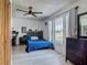 Well-lit bedroom featuring wood-look floors, a ceiling fan, a large window, and a dresser at 1129 Madura Dr, Deltona, FL 32725