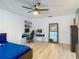Spacious bedroom featuring wood-look floors, a ceiling fan, a computer desk, and full length mirror at 1129 Madura Dr, Deltona, FL 32725