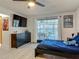 Bright bedroom featuring wood-look floors, a ceiling fan, and sliding glass doors to a screened patio at 1129 Madura Dr, Deltona, FL 32725