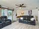 Living room with wood-look floors and comfortable seating, open to the kitchen area at 1129 Madura Dr, Deltona, FL 32725