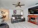 Comfortable living room features wood-look floors, a fireplace and a large sofa for relaxing at 1129 Madura Dr, Deltona, FL 32725