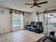 Living room featuring wood-look floors, comfortable seating, and views of the backyard pool at 1129 Madura Dr, Deltona, FL 32725