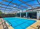 Backyard with a large, screened-in pool, enclosure, and lounge chairs poolside at 1129 Madura Dr, Deltona, FL 32725