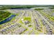 Expansive aerial view of a well-planned community with a central clubhouse, pool, green spaces, and scenic lakes at 11479 Satire St, Orlando, FL 32832