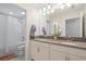 The bathroom features a double vanity with a large mirror, white cabinetry, and a separate shower and toilet room at 11479 Satire St, Orlando, FL 32832