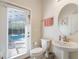Well-lit bathroom features a pedestal sink, and access to the outdoor pool area, enhancing convenience and style at 11479 Satire St, Orlando, FL 32832