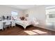 Bright bedroom featuring hardwood floors, a large window, and a hanging egg chair, creating a cozy and inviting space at 11479 Satire St, Orlando, FL 32832