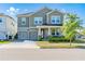 Charming two-story home features a two-car garage, landscaped yard, and inviting front porch at 11479 Satire St, Orlando, FL 32832