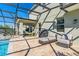 Relaxing screened-in patio with a pool, outdoor seating, and a hammock, offering a perfect space for leisure at 11479 Satire St, Orlando, FL 32832