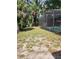 Spacious grassy backyard with a screened-in pool at 1245 Emeralda, Orlando, FL 32808