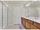 Bright bathroom featuring a double sink vanity, framed mirror, and a glass enclosed shower stall at 14335 Sapelo Beach Dr, Orlando, FL 32827