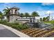 Elegant community entrance featuring stone tower, water feature and lush landscaping under a bright blue sky at 14335 Sapelo Beach Dr, Orlando, FL 32827