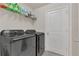 Well-equipped laundry room featuring dark front load washer and dryer, plus storage shelves at 14335 Sapelo Beach Dr, Orlando, FL 32827