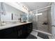 Bathroom features double vanity with black cabinets, large mirrors and glass enclosed shower at 15693 Kinnow Mandarin Ln, Winter Garden, FL 34787