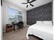 Cozy bedroom featuring a statement wall, ceiling fan, large window, and a desk at 15693 Kinnow Mandarin Ln, Winter Garden, FL 34787