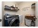 Well-organized laundry room featuring modern washer and dryer, shelving, and laundry-themed wall decor at 15693 Kinnow Mandarin Ln, Winter Garden, FL 34787