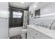 Modern bathroom with sleek black tiled walls, marble vanity and subway tile tub at 2072 Grandview S Ave, Sanford, FL 32771