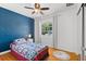 Vibrant bedroom with bright blue accent wall, hardwood floors, and a ceiling fan at 2072 Grandview S Ave, Sanford, FL 32771