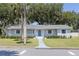 Charming single-story home with a well-manicured lawn, blue door, and mature trees at 2072 Grandview S Ave, Sanford, FL 32771