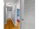 Hallway with hardwood floors leading to bedroom featuring a colorful quilt and blue accent wall at 2072 Grandview S Ave, Sanford, FL 32771