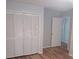 Bedroom view with closet and white louvered doors and wooden flooring at 2181 Wekiwa Oaks Dr, Apopka, FL 32703
