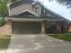 Exterior view of a two-story house with a two-car garage and brick accents at 2181 Wekiwa Oaks Dr, Apopka, FL 32703