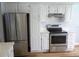 Modern kitchen with stainless steel appliances, white cabinets, and light countertops at 2181 Wekiwa Oaks Dr, Apopka, FL 32703