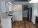 Updated kitchen featuring white cabinets, stainless steel appliances, and wood-look flooring at 2181 Wekiwa Oaks Dr, Apopka, FL 32703