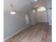 Open-concept living room with vaulted ceilings, light hardwood floors, stylish light fixtures, and access to other rooms at 2181 Wekiwa Oaks Dr, Apopka, FL 32703