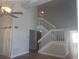 Bright living room with vaulted ceilings, modern ceiling fan, staircase and wood-look floors at 2181 Wekiwa Oaks Dr, Apopka, FL 32703