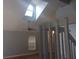 Open-concept living room featuring vaulted ceilings, a skylight, and light hardwood floors with the staircase visible at 2181 Wekiwa Oaks Dr, Apopka, FL 32703
