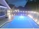 A spacious pool with reflective blue water and a fence at twilight at 2181 Wekiwa Oaks Dr, Apopka, FL 32703