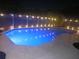 Outdoor in-ground pool with lights strung along the fence at night at 2181 Wekiwa Oaks Dr, Apopka, FL 32703