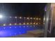 A gorgeous, lit swimming pool at night with reflective blue water and a fenced perimeter at 2181 Wekiwa Oaks Dr, Apopka, FL 32703