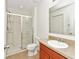 Bathroom features a shower, toilet and sink with wood cabinets and a large mirror at 2311 Chatham Place Dr, Orlando, FL 32824