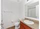 Bathroom features a toilet, sink with wood cabinets and a large mirror and towel rack at 2311 Chatham Place Dr, Orlando, FL 32824