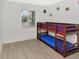 Bedroom with new floors, a window with blinds, and a bunk bed with blue and purple sheets at 2311 Chatham Place Dr, Orlando, FL 32824