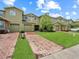 Attractive two-story home featuring a lush green lawn and brick driveway at 2311 Chatham Place Dr, Orlando, FL 32824