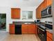 Bright kitchen with a window above the sink, stainless steel appliances, and wood cabinets at 2311 Chatham Place Dr, Orlando, FL 32824