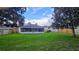 Expansive backyard with lush green grass, screened-in lanai, and privacy fence at 2555 Palmetto Ridge Cir, Apopka, FL 32712